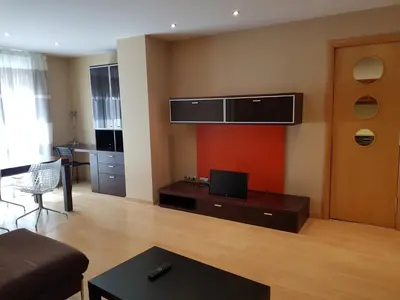 a living room with a couch and a tv on the wall at Pis de bon disseny i sostenible. in Manresa