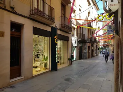 an empty street with shops and a person walking down the street at Pis de bon disseny i sostenible. in Manresa