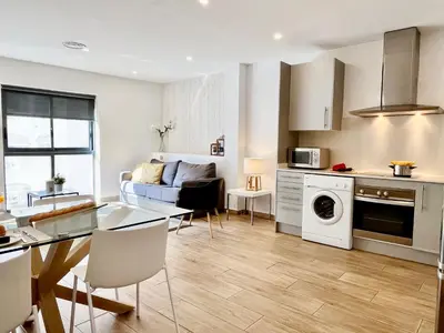 a kitchen and living room with a table and a couch at Feelathome Mozart Apartments in Barcelona