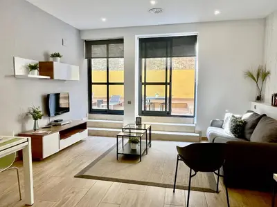 a living room with a couch and a tv at Feelathome Mozart Apartments in Barcelona