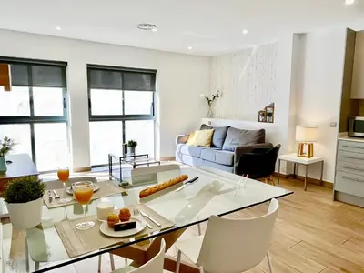 a living room with a table and a couch at Feelathome Mozart Apartments in Barcelona