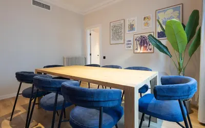 a conference room with a wooden table and blue chairs at Stay U-nique Apartments Balmes II in Barcelona