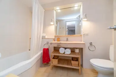 a bathroom with a sink and a toilet and a mirror at Piso con vista increíble al mar in Sant Andreu de Llavaneres