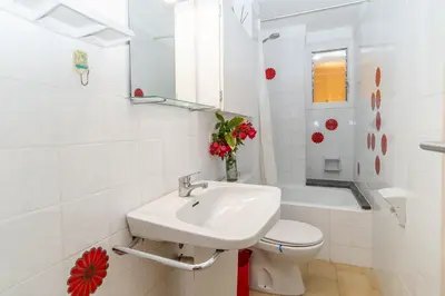 a white bathroom with a sink and a toilet at Piso con vista increíble al mar in Sant Andreu de Llavaneres