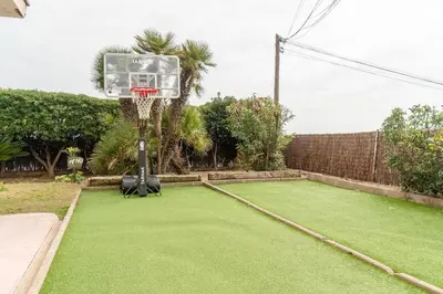 a basketball hoop in a yard with a green lawn at Piso con vista increíble al mar in Sant Andreu de Llavaneres
