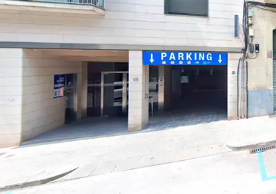 a parking garage with a sign on the side of a building at Pis clar i espaiós in Manresa