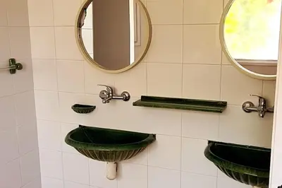 a bathroom with two green sinks and a mirror at Villa Apartment with Pool and Amazing Views! in Arenys de Mar