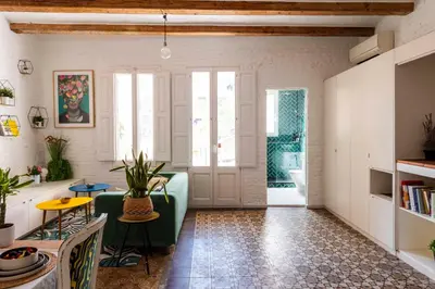 a living room with a green couch and a table at Enchanting 2 BR flat with terrace near Plaça Espanya in Barcelona
