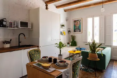 a kitchen with a table and chairs in a room at Enchanting 2 BR flat with terrace near Plaça Espanya in Barcelona