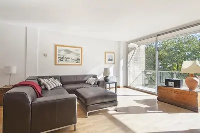a living room with a couch and a large window at Vila Olimpica Skyline in Barcelona