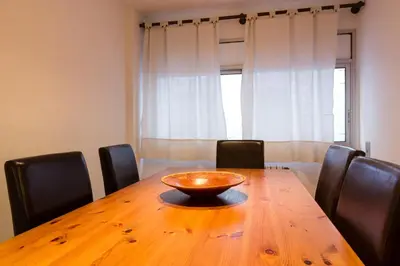 a wooden table with chairs and a bowl on top of it at Vila Olimpica Skyline in Barcelona
