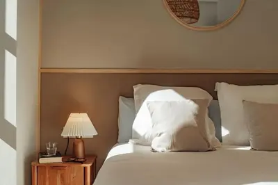 a bed with white pillows and a table with a lamp at Casa Macaya - 1b apartment in Eixample in Barcelona