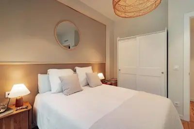 a bedroom with a large white bed and a mirror at Casa Macaya - 1b apartment in Eixample in Barcelona