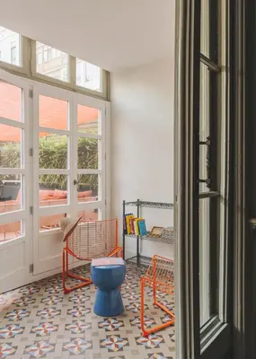 a room with a blue stool and a room with windows at Piulet Hostel in Barcelona
