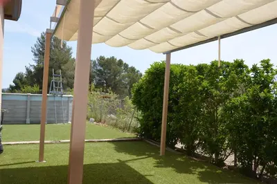 a white pergola in a yard with a tree at Casa Santa Creu - Private family villa in nature in Piera