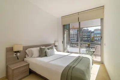 a bedroom with a large bed and a large window at Stay Unique Apartments Pau Claris con piscina in Barcelona