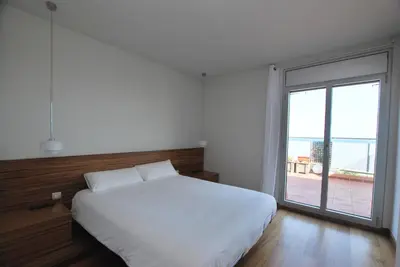 a bedroom with a white bed and a large window at Picasso Street in Vilassar de Mar