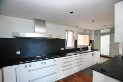a kitchen with white cabinets and black counter tops at Picasso Street in Vilassar de Mar