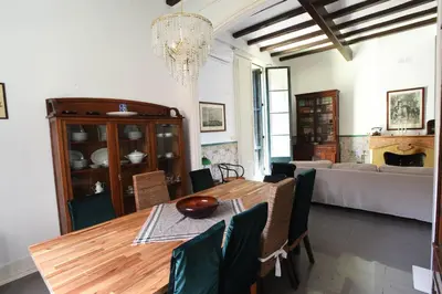 a dining room with a table and a couch at Vila d'Alba in Sant Andreu de Llavaneres