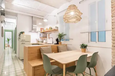 a bedroom with a white bed and a chair at Charming renovated Apt minutes from the center in Barcelona