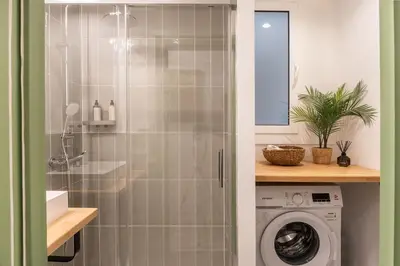 a bedroom with a white bed with blue pillows at Charming renovated Apt minutes from the center in Barcelona