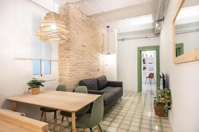 a living room with a couch and a brick wall at Charming renovated Apt minutes from the center in Barcelona