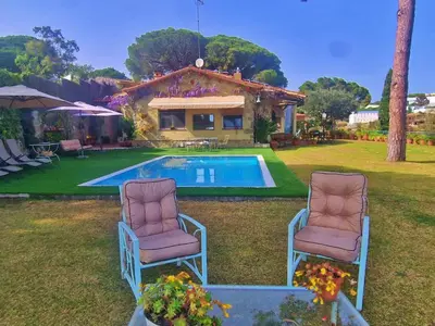 two chairs sitting in front of a swimming pool at Preciosa casa al borde de un acantilado in Arenys de Mar