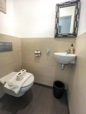 a bathroom with a white toilet and a sink at Atalaya Apartment by Hello Homes Sitges in Sitges