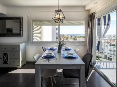 a dining room with a table and a large window at Atalaya Apartment by Hello Homes Sitges in Sitges