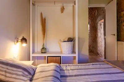 a bedroom with a bed and a table with a vase at Cal Simon- Casa a Montserrat in Collbató