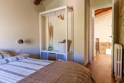 a bedroom with a bed and a mirror at Cal Simon- Casa a Montserrat in Collbató
