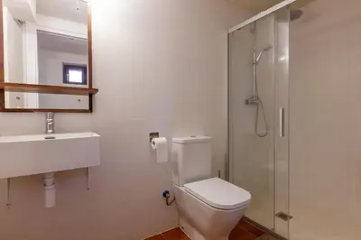a bathroom with a toilet and a sink and a shower at Cal Simon- Casa a Montserrat in Collbató