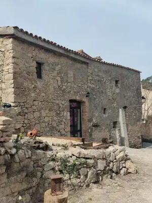 an old stone building with a stone wall at Cal Simon- Casa a Montserrat in Collbató