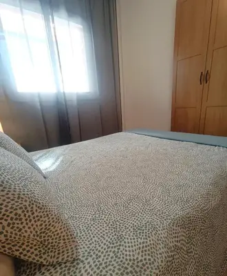 a bed in a room with a window and a bedspread at Apartamento Gerimar - Gelida/Bcn in Gélida