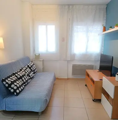 a living room with a blue couch and a desk at Apartamento Gerimar - Gelida/Bcn in Gélida