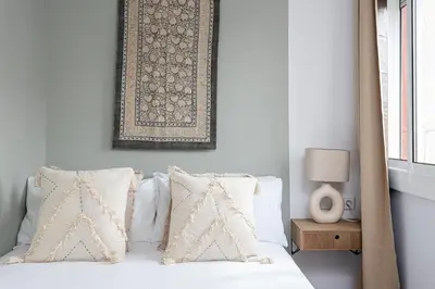 a bedroom with a bed with pillows and a picture on the wall at 3 Bdr Apt In Cornella 5 Mins Form The Metro in Cornellà de Llobregat