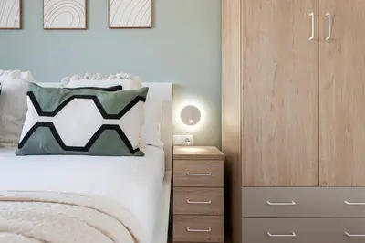 a bedroom with a bed and a wooden cabinet at Lovely Attic With Terrace in Hospitalet de Llobregat