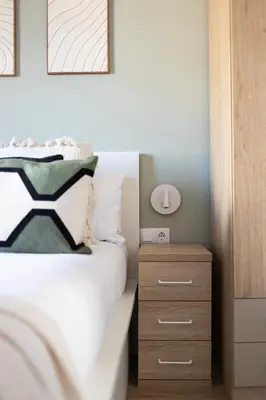 a bedroom with a bed and a wooden nightstand at Lovely Attic With Terrace in Hospitalet de Llobregat