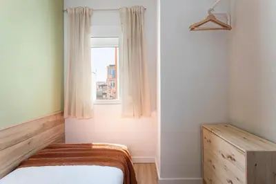 a bedroom with a bed and a window at Lovely Attic With Terrace in Hospitalet de Llobregat