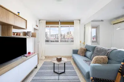 a living room with a blue couch and a tv at 2 Bdr Apt In Cornella 5 Mins Form The Metro in Cornellà de Llobregat