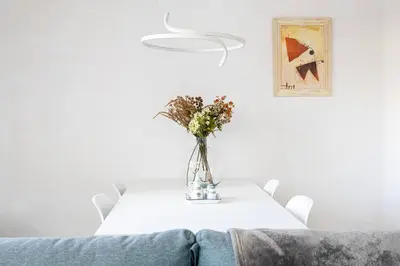 a white table with a vase of flowers on it at 2 Bdr Apt In Cornella 5 Mins Form The Metro in Cornellà de Llobregat