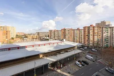 a large building with a parking lot in a city at Cozy Apt In Cornella 2 Mins From The Metro in La Gabarra