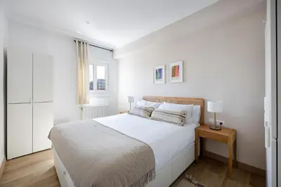 a white bedroom with a bed and a window at Amazing 3bdr Apt In Cornella 1 Mins From Metro in Cornellà de Llobregat