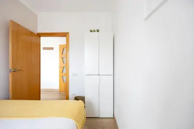 a bedroom with two beds and a white closet at Amazing 3bdr Apt In Cornella 1 Mins From Metro in Cornellà de Llobregat