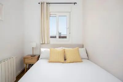 a bedroom with a white bed and a window at Amazing 3bdr Apt In Cornella 1 Mins From Metro in Cornellà de Llobregat