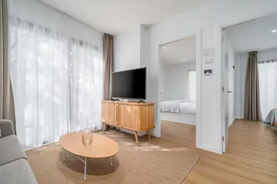 a living room with a television on a wooden table at Limehome Barcelona Plaça Pirineus in Hospitalet de Llobregat