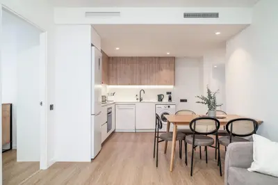 a kitchen and dining room with a table and chairs at Limehome Barcelona Plaça Pirineus in Hospitalet de Llobregat