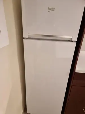 a white refrigerator freezer sitting in a kitchen at Cozy Apartment downtown BCN, AC, 30 nigths min in Barcelona