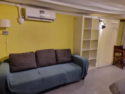 a living room with a blue couch in a room at Cozy Apartment downtown BCN, AC, 30 nigths min in Barcelona