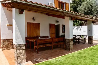 a pavilion with a table and chairs on a patio at Ca L’Oscana in Bigues i Riells